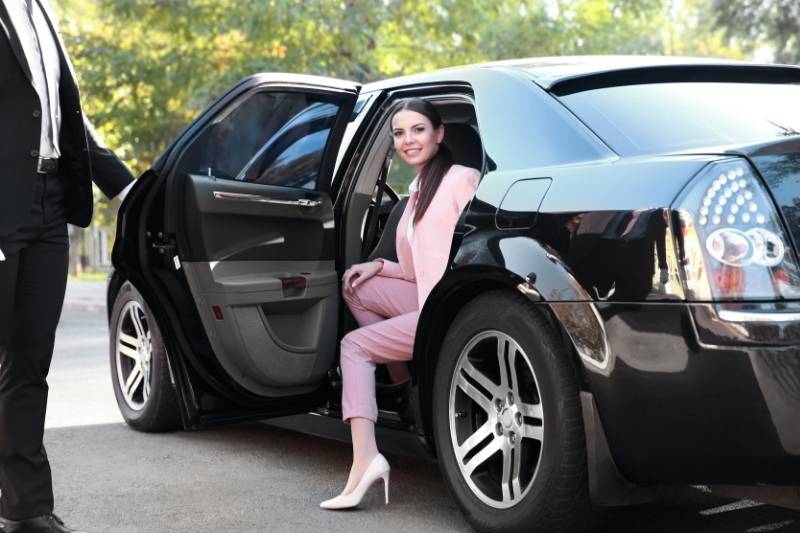 Women is coming out of her black car